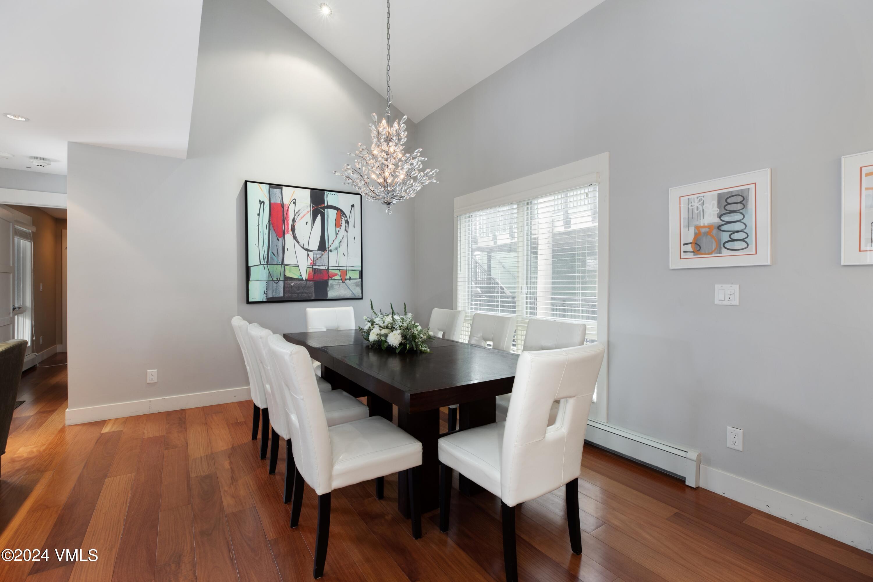 963 Lions Ridge Loop, Unit 535 Vail, CO 81657 - Photo 3 of 26 a view of a dining room with furniture wooden floor and chandelier
