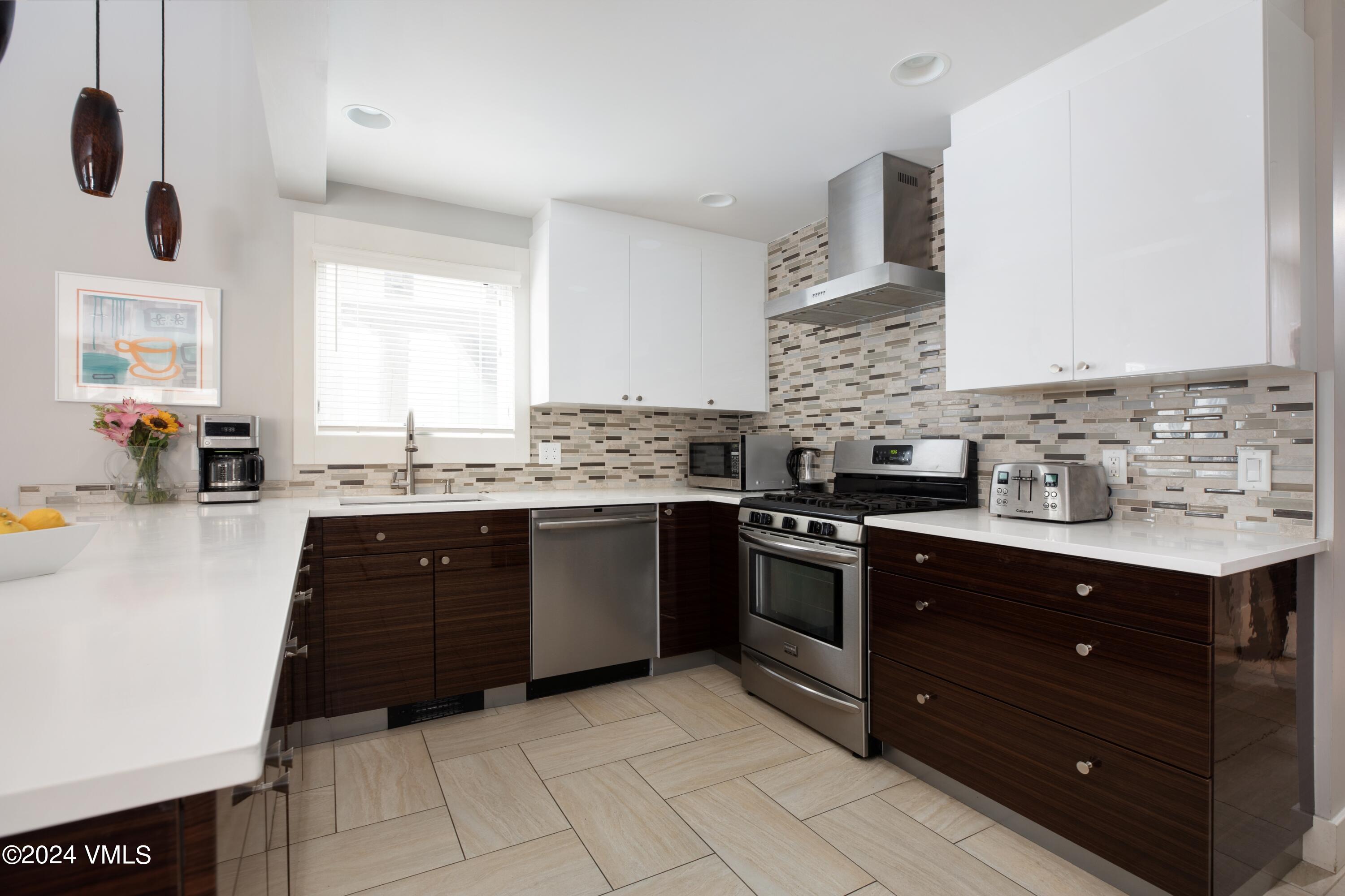 963 Lions Ridge Loop, Unit 535 Vail, CO 81657 - Photo 5 of 26 a kitchen with a sink stove and cabinets