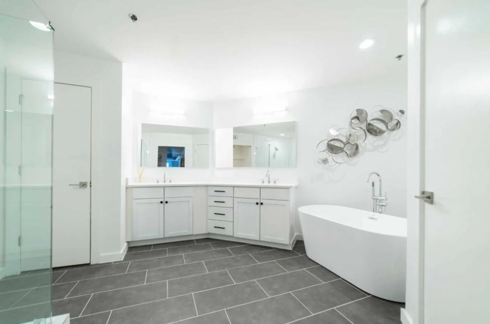 230 18th Street Northwest, Unit 11325 Atlanta, GA 30363 - Photo 13 of 43 a bathroom with a double vanity sink a mirror and a bathtub