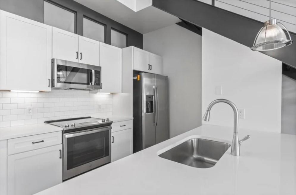 230 18th Street Northwest, Unit 11325 Atlanta, GA 30363 - Photo 22 of 43 a kitchen with granite countertop a sink stainless steel appliances and cabinets