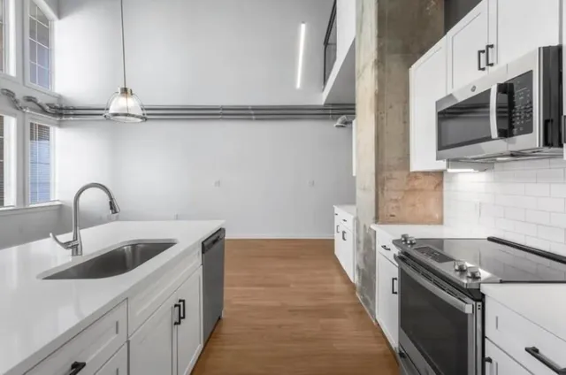 a kitchen with stainless steel appliances granite countertop a sink and a stove