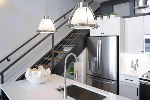 a kitchen with stainless steel appliances granite countertop a refrigerator a stove and a sink