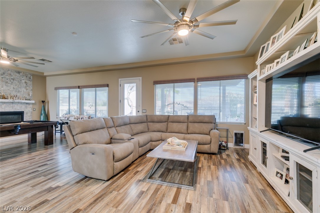 7524 Midnight Rambler Street Las Vegas, NV 89149 - Photo 15 of 51 A well-lit great room features rich wood flooring, a decorative fireplace, and ample natural illumination.