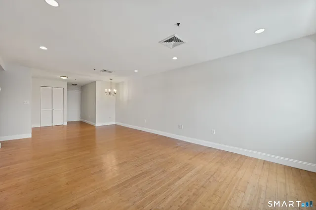 a view of empty room with wooden floor