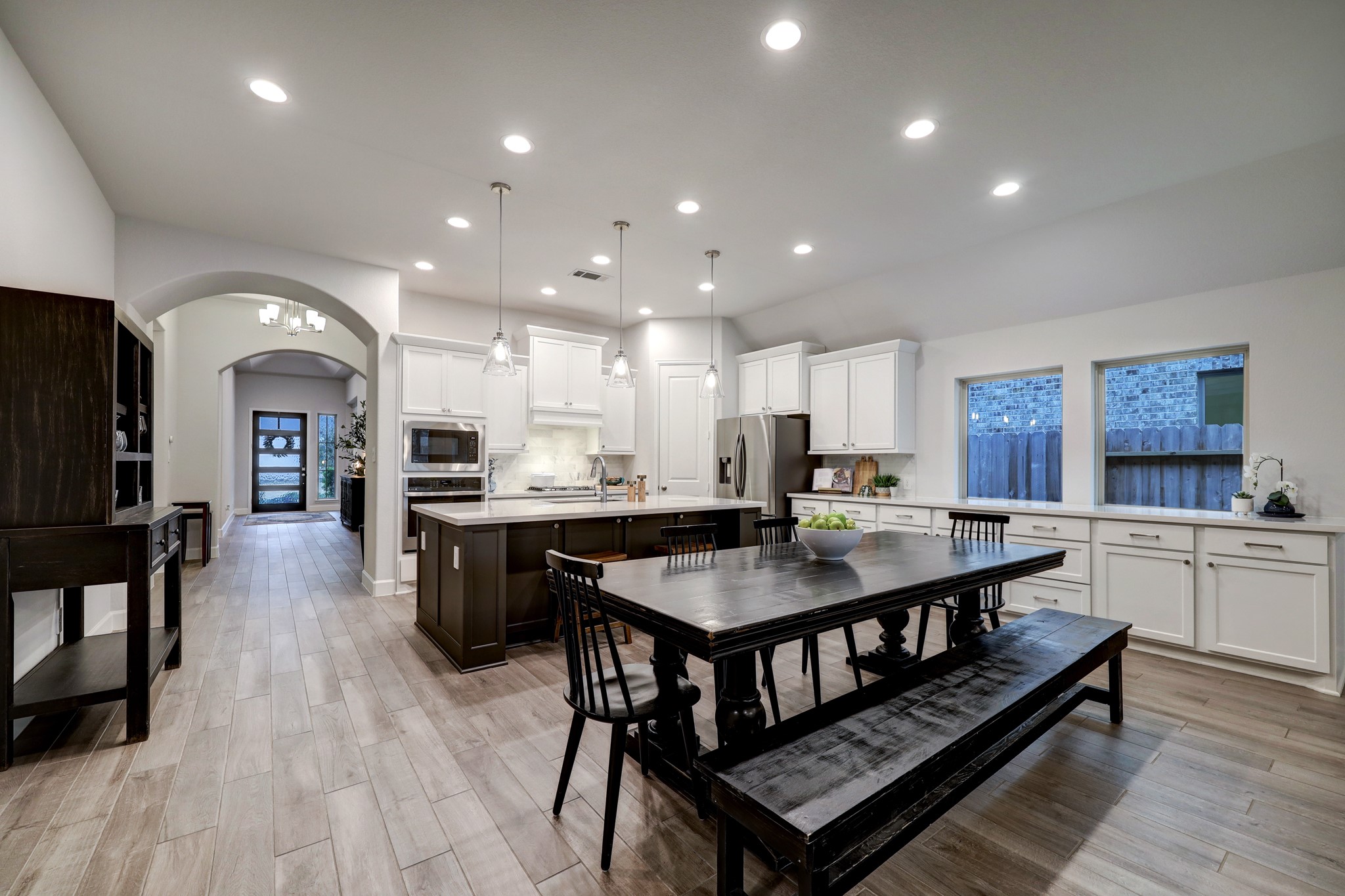 804 Fall Rock Branch Drive Conroe, TX 77304 - Photo 15 of 44 a dining hall with stainless steel appliances granite countertop a stove a sink dishwasher a dining table and chairs with wooden floor