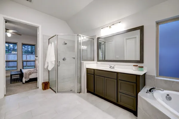 a bathroom with a tub sink and mirror