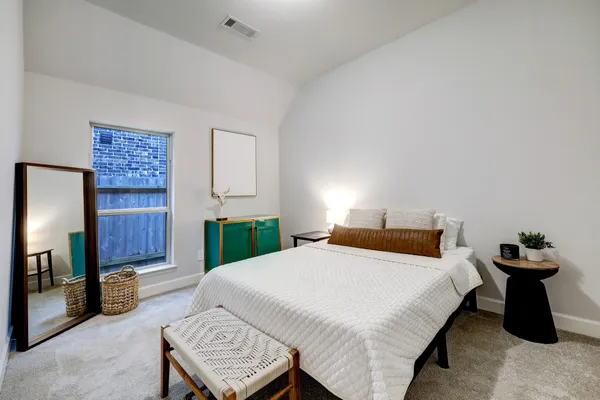 a bedroom with a bed and a lamp on desk