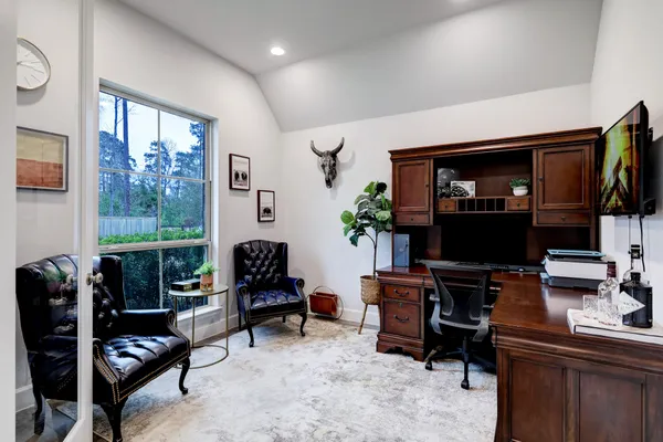 a living room with furniture a flat screen tv and a window