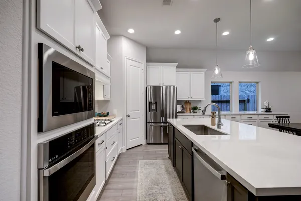 a kitchen with stainless steel appliances granite countertop a sink a stove and a refrigerator