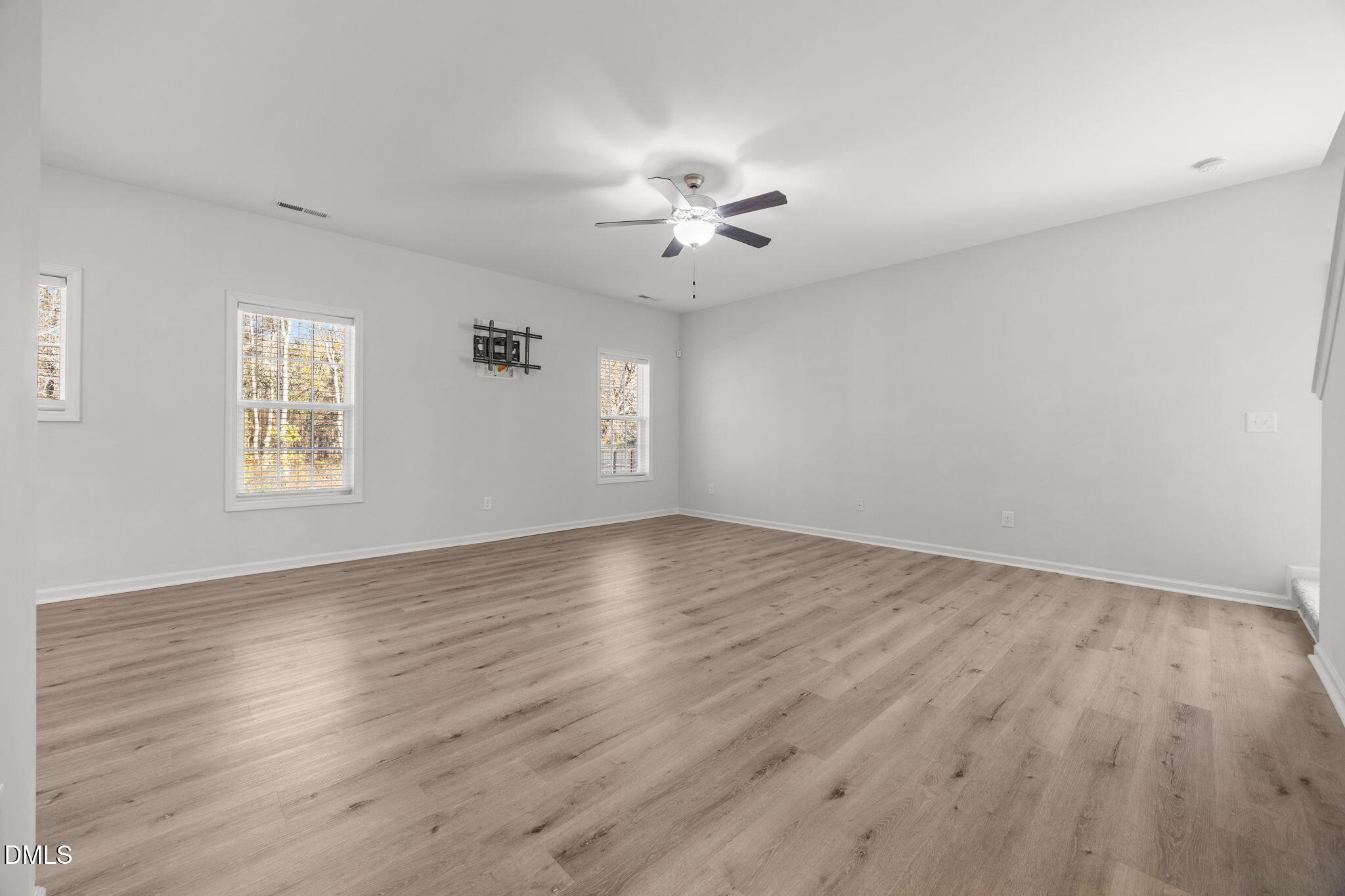 161 Starlight Road Lillington, NC 27546 - Photo 17 of 45 an empty room with wooden floor ceiling fan and windows