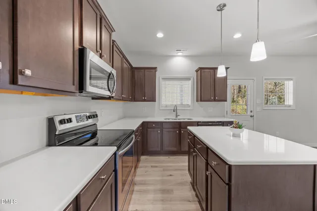 a kitchen that has a sink a stove and a microwave