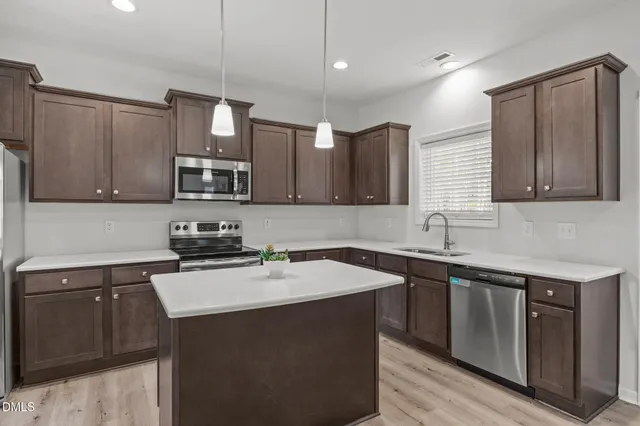 a kitchen with stainless steel appliances a sink stove and microwave