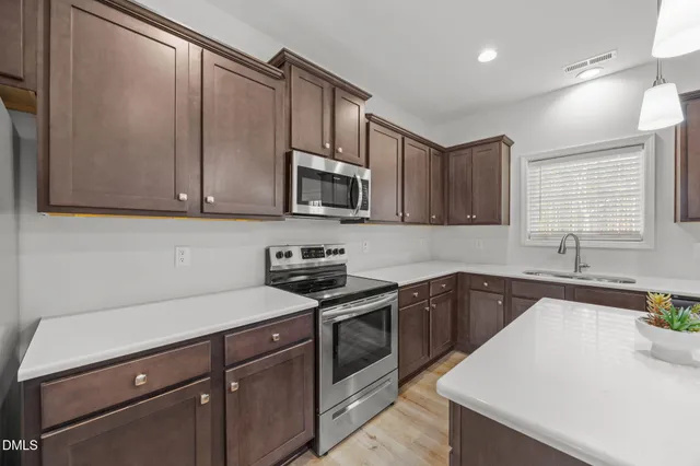 a kitchen with a sink a stove and cabinets