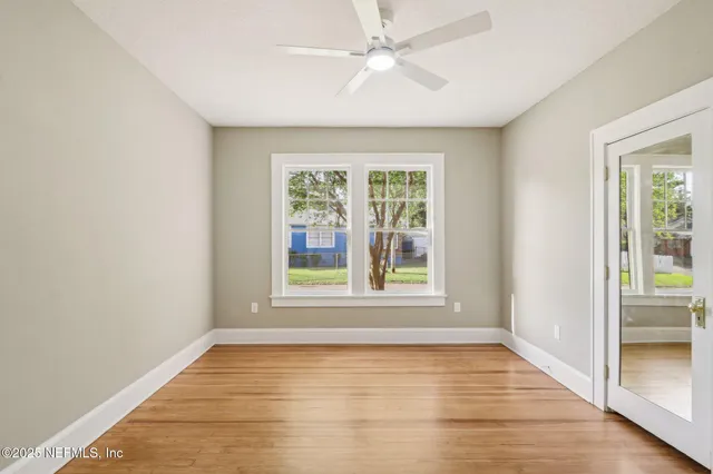 a view of a room with wooden floor and a ceiling fan