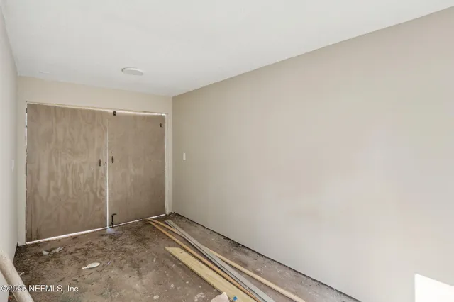 a view of backyard with wooden fence and large trees
