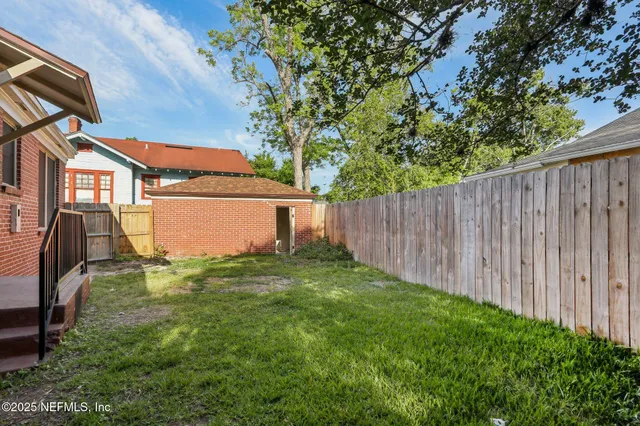 a view of a house with a big yard and large trees