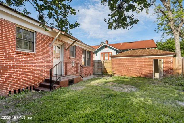 a view of a house with a big yard and large tree
