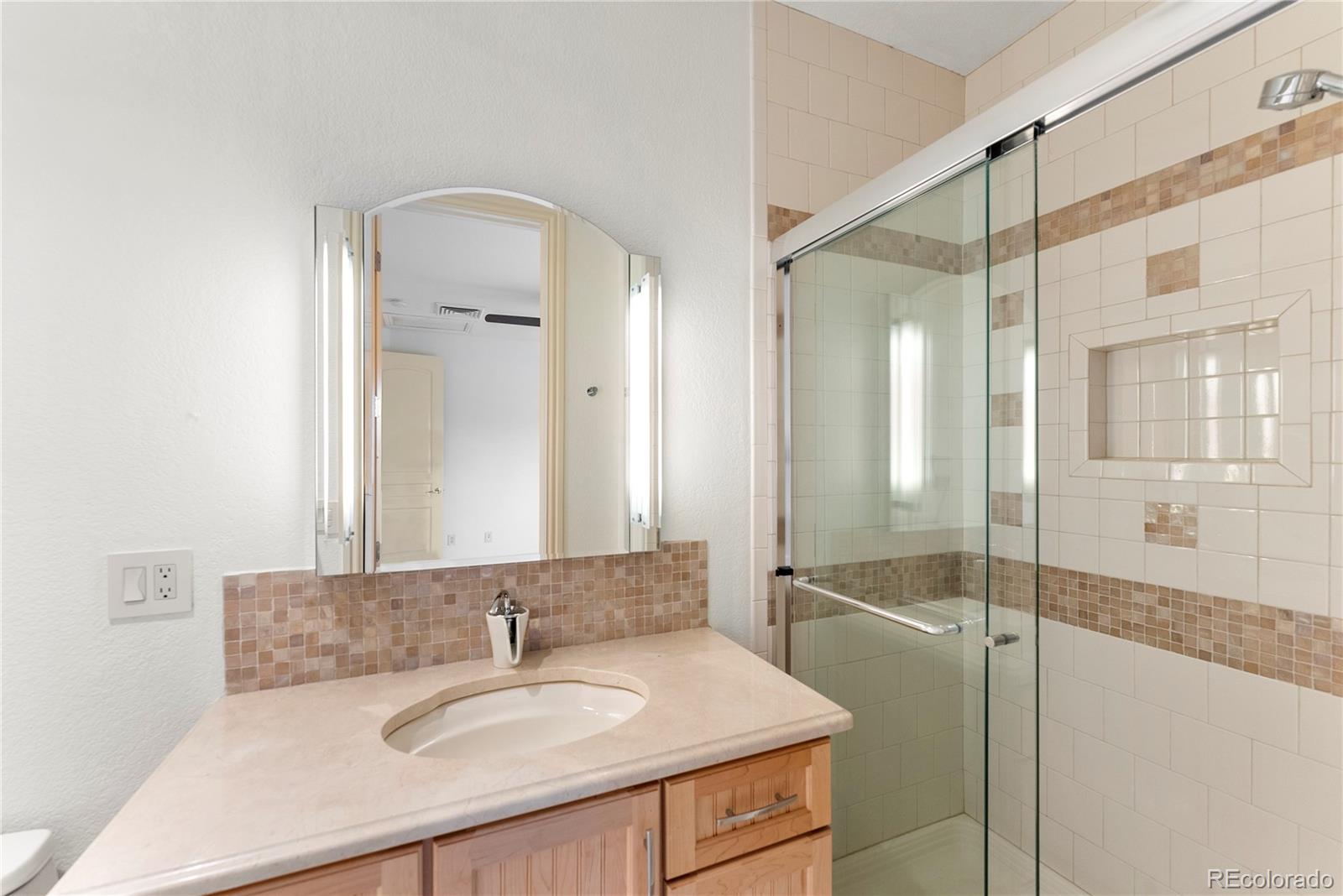 14046 Lexington Circle Westminster, CO 80023 - Photo 37 of 40 a bathroom with a sink and a mirror