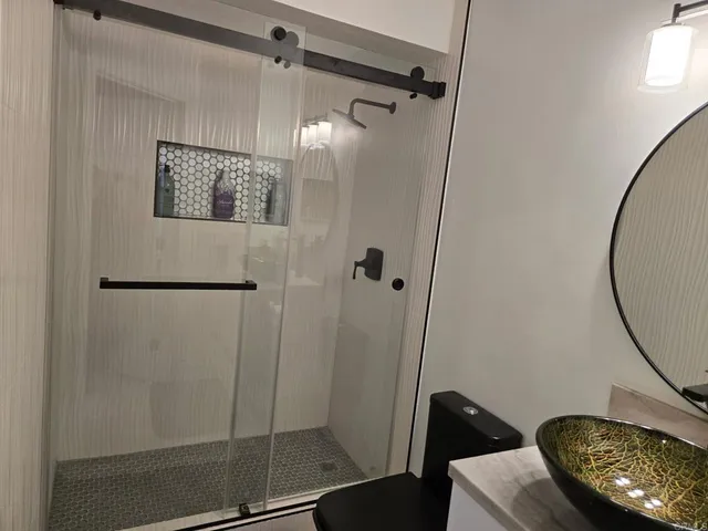 a bathroom with a toilet a sink and shower