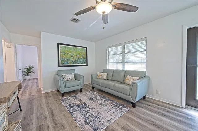 a living room with furniture and wooden floor