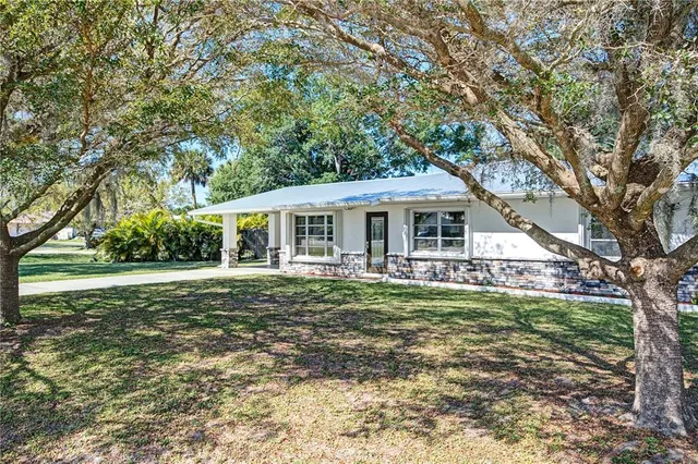 a view of a house with backyard and tree