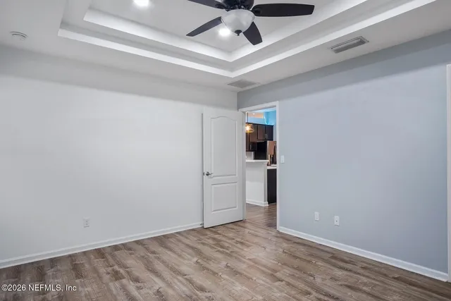 a view of empty room with wooden floor
