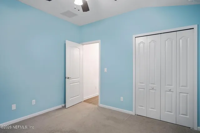 an empty room with chandelier fan