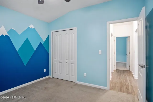 an empty room with wooden floor and a bathroom