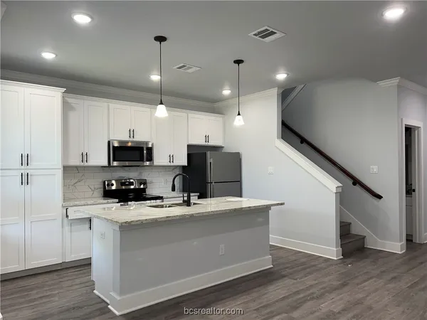 a kitchen with stainless steel appliances a refrigerator sink and microwave