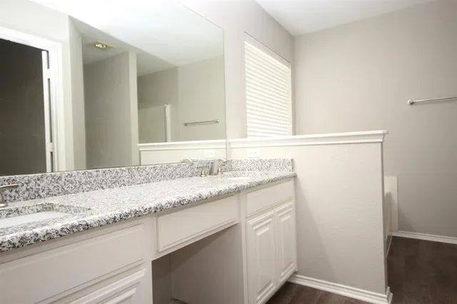 a bathroom with a granite countertop sink and a bathtub