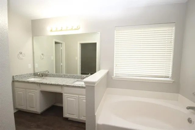 a bathroom with a tub and a large window