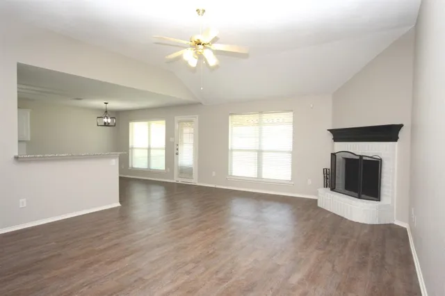 a view of an empty room with a fireplace and a window