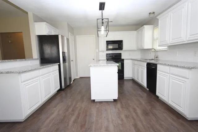 a kitchen with white cabinets stainless steel appliances and sink