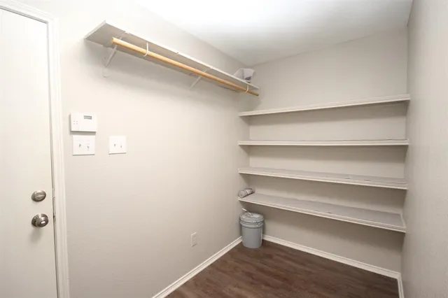 a view of walk in closet with empty racks