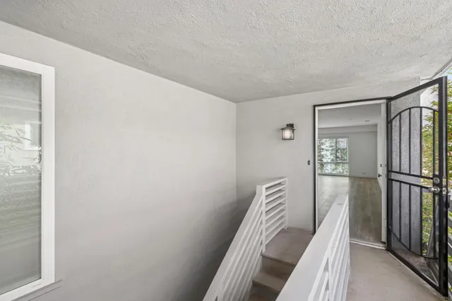 a view of a hallway with wooden floor and staircase
