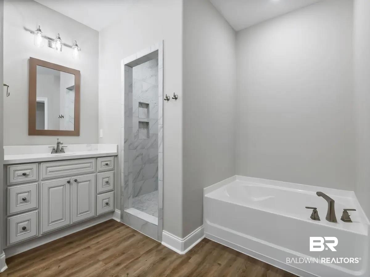10174 Grady Lane Mobile, AL 36695 - Photo 10 of 14 Bathroom featuring vanity, a garden tub, dark wood-style flooring, and a marble finish shower