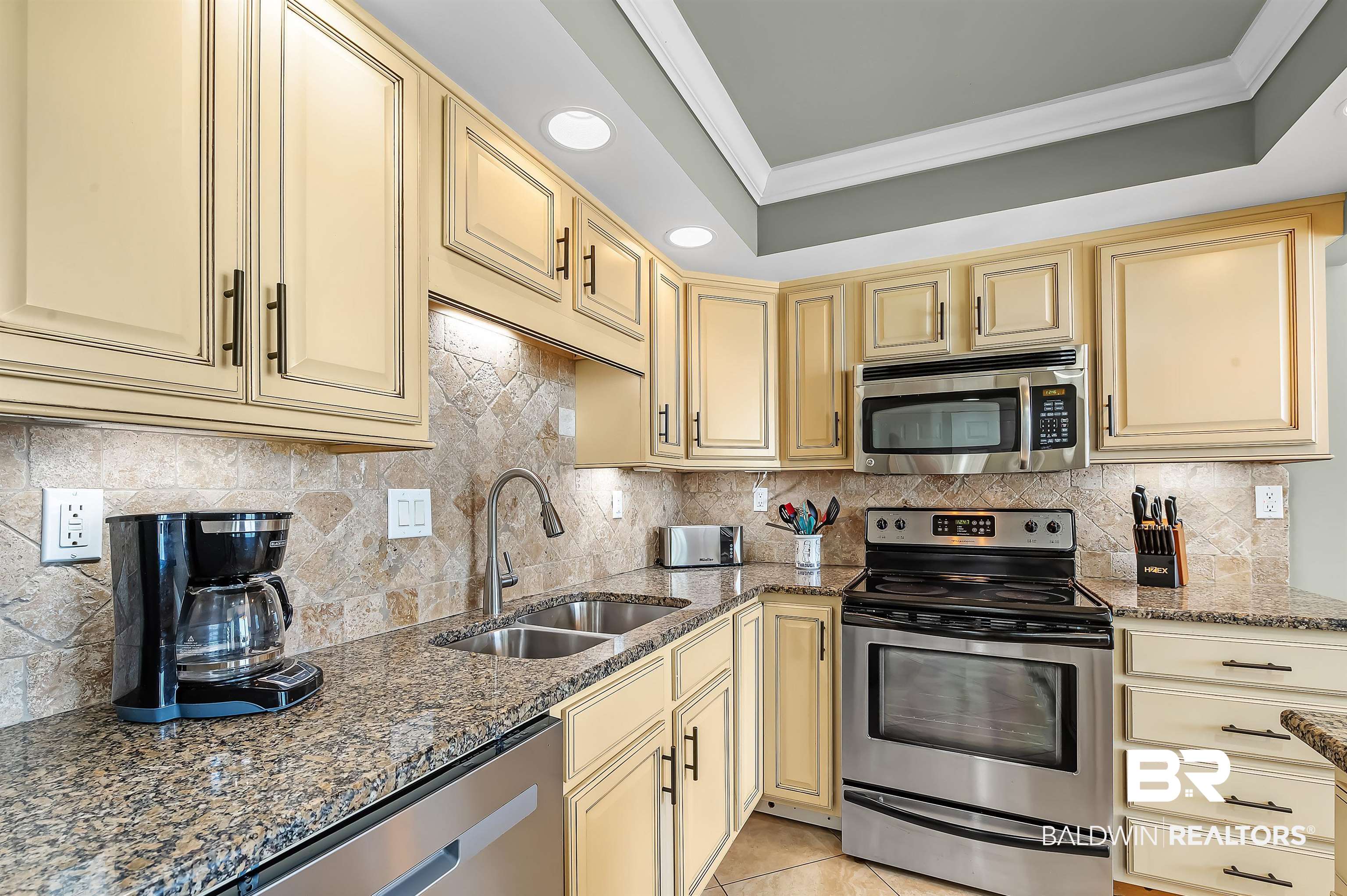 16287 Perdido Key Drive, Unit 105 Pensacola, FL 32507 - Photo 24 of 66 Kitchen featuring stainless steel appliances, granite countertops, stone tile backsplash, recessed lighting, and under-cabinet illumination