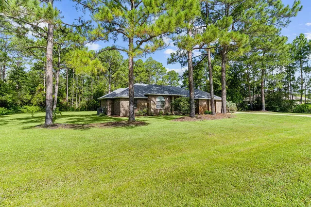a front view of a house with yard and green space