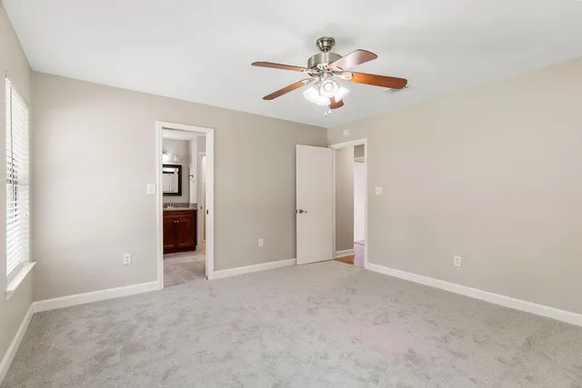 an empty room with closet and a chandelier fan