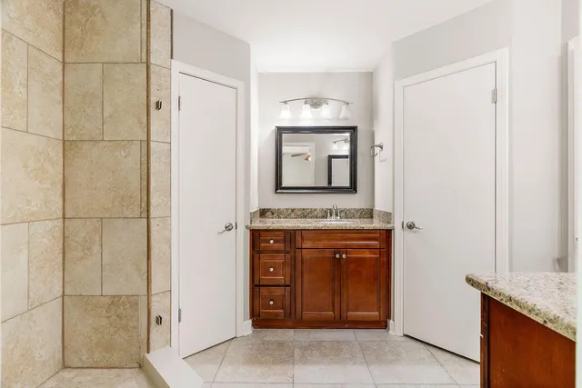 a bathroom with a granite countertop sink and a mirror