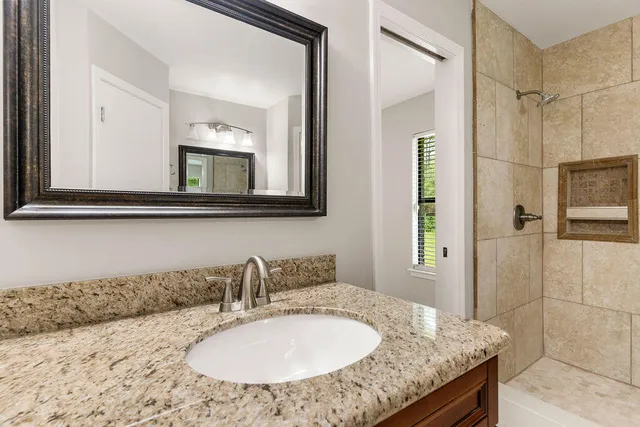 a bathroom with a granite countertop sink and a mirror