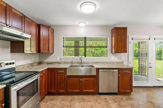 a kitchen with kitchen island granite countertop a sink stove and cabinets