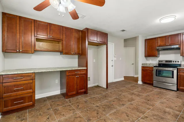 a kitchen with granite countertop wooden cabinets and stainless steel appliances