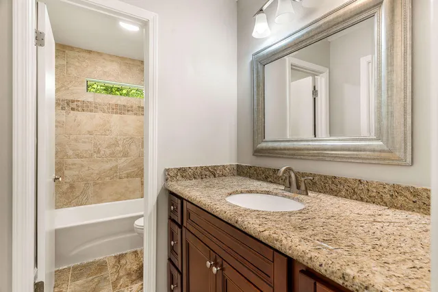 a bathroom with a granite countertop sink and a mirror