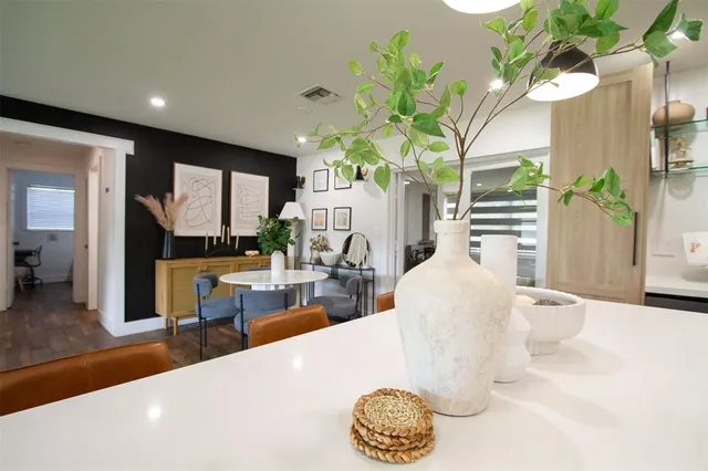 a living room with furniture a potted plant and a large window