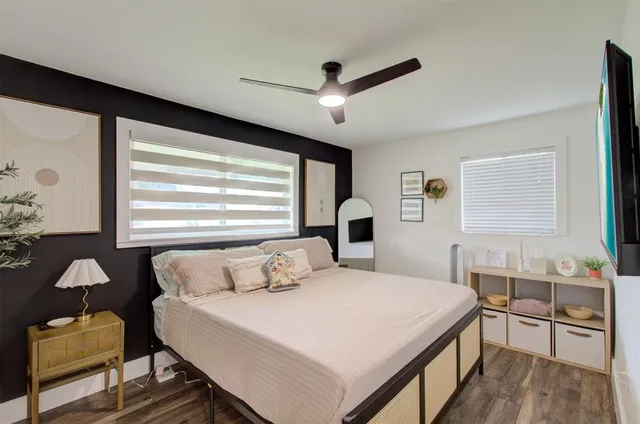 a bedroom with a bed a painting on the wall and a window