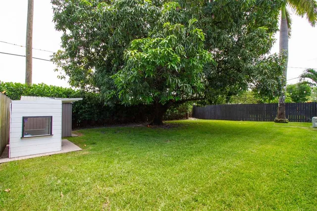an aerial view of residential house with outdoor space and trees all around