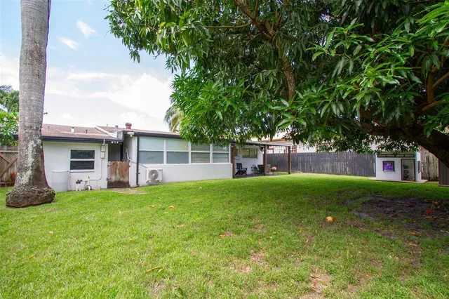 an aerial view of residential houses with outdoor space and trees