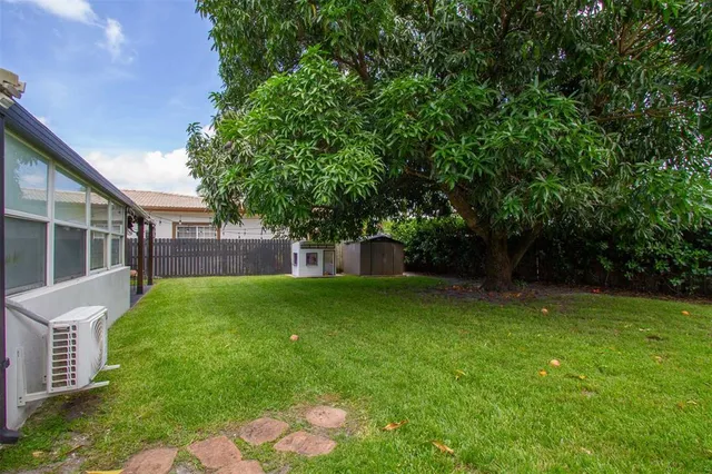 an aerial view of residential houses with outdoor space and trees