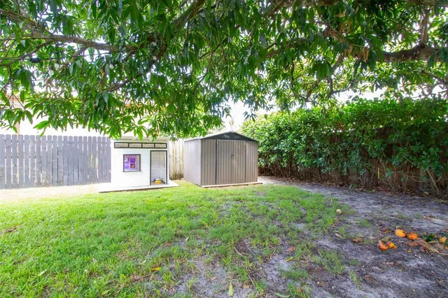 an aerial view of residential houses with outdoor space and trees